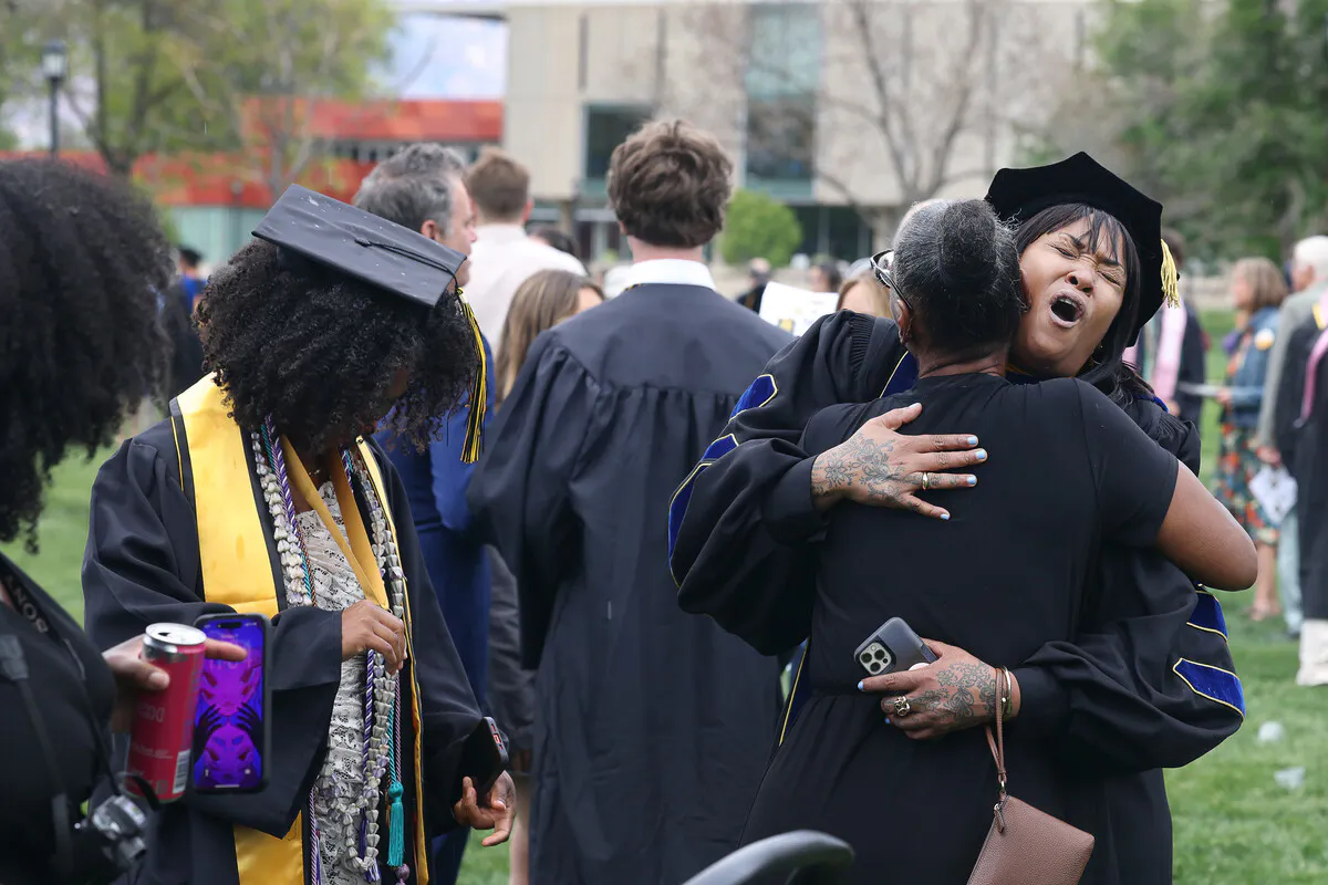 Heidi R. Lewis, Professor, David & Lucile Packard Professor, Feminist and Gender Studies, hugs a student's loved one at Commencement on Sunday, May 17. Photo by Jamie Cotten / Colorado College